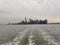 Skyline of New York urban buildings on the otherside of the water with sunset gray sky