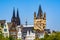 Skyline of the old town with solorful houses rooftops, the tower of the Cologne gothic cathedral and the tower of Gtreat St.