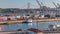Skyline over Lisbon commercial port timelapse, 25th April Bridge, containers on pier with freight cranes