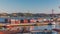 Skyline over Lisbon commercial port timelapse, 25th April Bridge, containers on pier with freight cranes