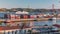 Skyline over Lisbon commercial port timelapse, 25th April Bridge, containers on pier with freight cranes