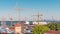 Skyline over Lisbon commercial port timelapse, containers on pier with freight cranes