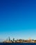 Skyline of uptown Manhattan over Hudson River under blue sky, at