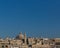 Skyline of Valletta, Malta under blue sky, with dome of Basilica of Our Lady of Mount Carmel and tower of St Paul`s Pro-Cathedral