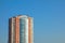 Skyscraper or flat block building on clear blue sky background. Closeup view with copy space. Modern urban architecture landscape