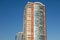 Skyscraper or flat block building on clear blue sky background. Closeup view of modern urban architecture landscape