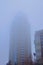 Skyscraper in Kyiv rises high into the foggy sky in the Obolon neighborhood, Kyiv, Ukraine
