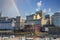 Skyscrapers and buildings in the city skyline along the water in Wolf Creek Harbor with blue sky and clouds and a rainbow