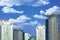 Skyscrapers or flat block buildings on clouds and blue sky background. Closeup view of modern urban architecture landscape cyan