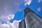 Skyscrapers. Looking Up To A Deep Blue Midday Sky With Clouds And Sunburst