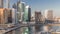 Skyscrapers near canal in Dubai with blue sky aerial timelapse