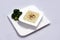 Slanted Hero Shot of a Broccoli Soup with bread crumbs, oregano on a minimal white background with a 45 degree front facing angle