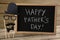 Slate with happy fathers day text by decoration on table