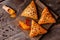 Slate plate with delicious samosas on rustic background, top view