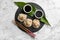 Slate plate with tasty baozi dumplings, chopsticks, sesame seeds and soy sauce on marble table