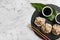 Slate plate with tasty baozi dumplings, chopsticks, sesame seeds and soy sauce on marble table, top view