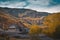 Slate roofs mountain houses in middle of a vivid colorful forest in autumn