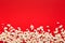 Slaty popcorn scattered on red background, top view