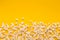 Slaty popcorn scattered on yellow background, top view