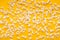 Slaty popcorn scattered on yellow background, top view