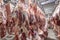 At the slaughterhouse, Carcasses, raw meat beef, hooked in the freezer. Close up of a half cow chunks fresh hung and arranged in a
