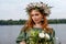 Slavic beauty with a floral wreath on her head and a bouquet of wildflowers. Ancient pagan origin celebration concept. Summer