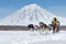 Sled dog team running on background of Kamchatka Volcano. Russia