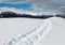 Sledge trace and footprints on winter mountain hill top