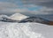 Sledge trace and footprints on winter mountain hill top