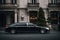 A sleek black limousine parked in front of a luxury hotel, ready to whisk away VIP guests.
