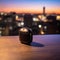 Sleek Black Wireless Earbud Charging Case on Wooden Desk with Cityscape in Background