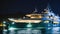 A sleek modern superyacht illuminated by a starry night