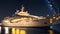 A sleek modern superyacht illuminated by a starry night