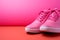 Sleek pink sneakers against a pink background, offering ample space