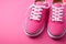 Sleek pink sneakers against a pink background, offering ample space