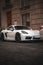 Sleek, white Porsche sports car is parked on a  city street