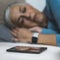 Sleep Apps - Tech-savvy Senior Woman Sleeping in Bed, Using Smart Phone and Smart Watch to Improve her Sleeping Habits