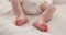 Sleeping, adorable and feet of baby on bed for child care, dreaming and relax in nursery. Family, cute and closeup of