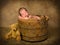 Sleeping baby in antique bucket