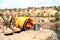 Sleeping bag, cup and boots on cliff near lake