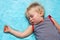 Sleeping blond haired child on blue