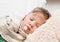 Sleeping boy lying in bed with a thermometer in mouth