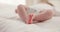 Sleeping, family and feet of baby on bed for child care, dreaming and relax in nursery. Adorable, cute and closeup of