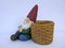 Sleeping garden gnome, sitting, leans against a basket. on white background