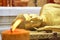Sleeping golden Buddha behind a burning candle