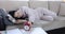 Sleeping lazy woman lies on sofa and turns off ringing alarm clock
