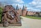Sleeping lion sculpture from iron in front of the Holsten gate or Holstentor, the landmark of the historic hanseatic city of