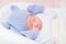 Sleeping little baby wearing knitted blue hat with ears