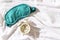 Sleeping mask and alarm clock on the white silk bedding in the morning. Sweet dreams concept