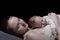 Sleeping mother with a sleeping baby on her chest, a moment of tenderness. Black background, space for text